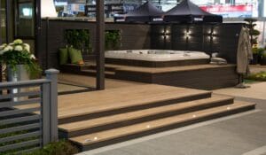 Kansi, jossa on biljardipöytä ja sateenvarjot. Kuvassa on mustan ja harmaan värit. Sisältää kasvi- ja ruukkukasveja. Huoneessa on myös ulkona, portaita, rakennus.