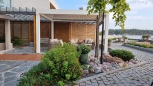 Talo, jossa on kivipatio. Kuvassa on harmaa ja valkoinen väri. Huoneessa on myös ulkona, taivas, kiinteistö.