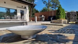 Valkoinen vene patiolla. Kuvassa on harmaat värit. Sisältää myös ulkona, maassa, rakennuksessa.