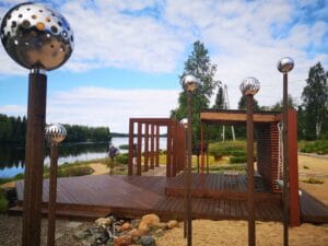 Puurakenne, jonka ympärillä on aita. Kuvassa on valkoinen ja ruskea väri. Mukana myös ulkona, taivas, pilvi.