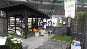 Rakennus, jossa on tiilinen kävelytie ja kivinen kävelytie. Kuvassa on harmaa ja musta väri. Mukana myös kasvi, kukkaruukku, huonekasvi.