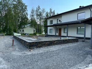 Talo, jossa on kiviseinä. Kuvassa on harmaat värit. Mukana myös ulkona, rakennuksena, taivaana.