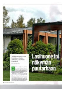 Kyltti talon edessä. Kuvassa on valkoinen ja vihreä väri. Sisältää myös tekstiä, kasvia, taivasta.