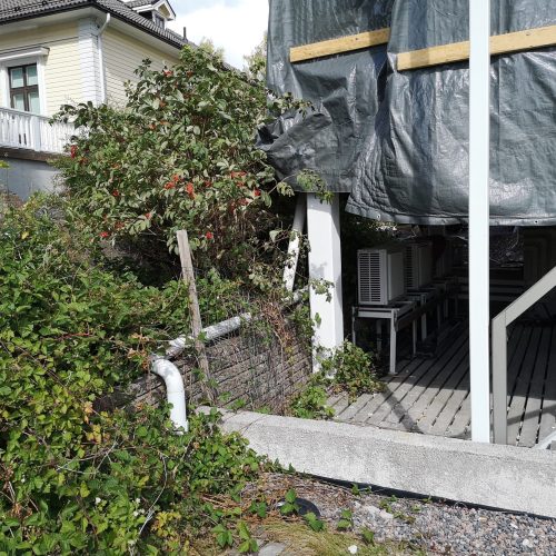 Talo, jossa on katettu kuisti. Kuvassa on harmaat ja mustavalkoiset värit. Sisältää myös ulkona, rakennuksen, kasvin.