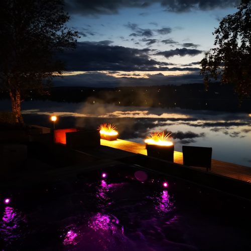 Talo, jossa on valot. Kuvassa on mustia värejä. Sisältää katuvalon ja puun. Mukana myös ulkona, pilvi, taivas.