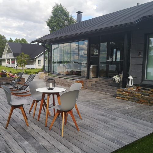 Pöytä ja tuolit kannella. Kuvassa on harmaa ja valkoinen väri. Sisältää puun, ruokapöydän ja tuolin. Huoneessa on myös ulkona, taivas, huonekalut.