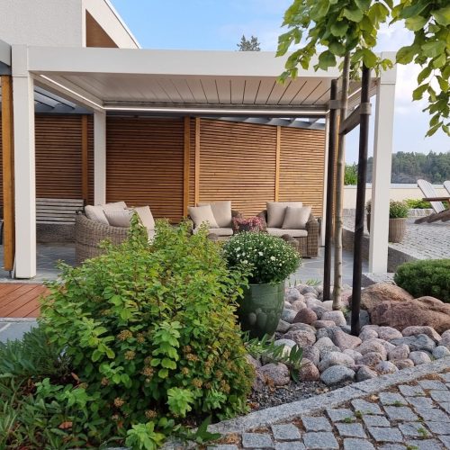 Talo, jossa on kivipatio. Kuvassa on harmaa ja valkoinen väri. Huoneessa on myös ulkona, taivas, kiinteistö.