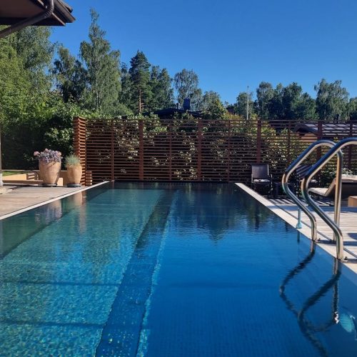 Uima-allas, jossa on kaide. Kuvassa on siniset värit. Sisältää myös ulkona, rakennuksen, puun.