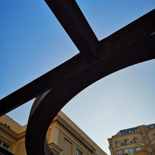 Silta, jonka taustalla on rakennus. Kuvassa on musta ja sininen väri. Huoneessa on myös taivas, ulkona, ikkuna.