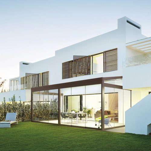 Talo, jossa on nurmikko ja tuolit. Kuvassa on valkoinen ja vihreä väri. Sisältää myös arkkitehtuuria, rakennusta, ulkona.