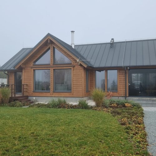 Talo, jossa on ajotie. Kuvassa on valkoinen ja harmaa väri. Sisältää asuntolan ikkunan ja talon. Sisältää myös ulkona, rakennuksen, kasvin.