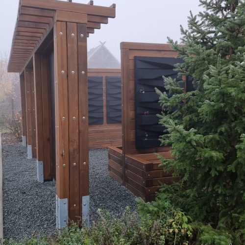 Rakennus, jossa on suuri lasi-ikkuna. Kuvassa on valkoisia värejä. Mukana myös ulkona, puu, taivas.