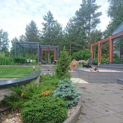 Talo, jossa on suuri etupiha. Kuvassa on harmaa ja vihreä ja valkoinen väri. Huoneessa on myös ulkona, taivas, maisemointi.