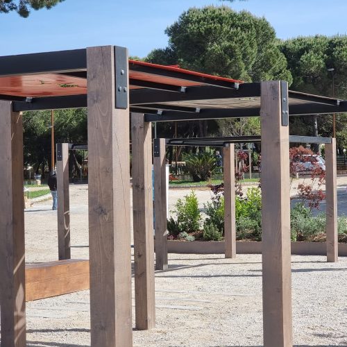 Puurakenne kyltillä. Kuvassa on harmaa ja valkoinen väri. Mukana myös ulkona, taivas, kasvi.